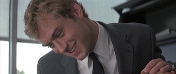 Movie still from “I Heart Huckabees” (2004), directed by David O. Russell – A person wearing a suit and tie; Close Up shot, Over the shoulder angle