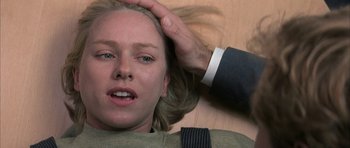 Movie still from “I Heart Huckabees” (2004), directed by David O. Russell – A woman laying on the ground with a man touching her hair; Close Up shot, Overhead angle