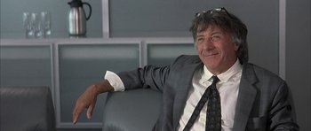 Movie still from “I Heart Huckabees” (2004), directed by David O. Russell – A man in a suit and tie sitting in a chair; Close Up shot, Low angle