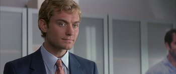 Movie still from “I Heart Huckabees” (2004), directed by David O. Russell – A man in a suit and tie looking at the camera; Close Up shot, Over the shoulder angle