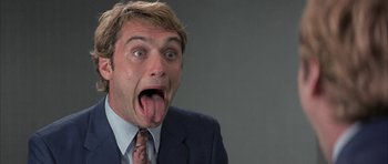 Movie still from “I Heart Huckabees” (2004), directed by David O. Russell – A person sticking out his tongue; Close Up shot, Low angle