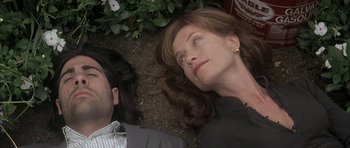 Movie still from “I Heart Huckabees” (2004), directed by David O. Russell – A woman and a man laying on the ground next to each other; Close Up shot, Overhead angle