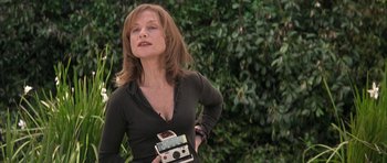 Movie still from “I Heart Huckabees” (2004), directed by David O. Russell – A woman holding an old camera in her hands; Medium shot, Low angle