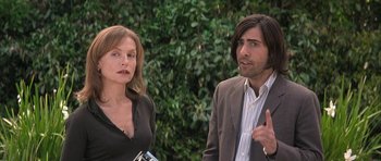 Movie still from “I Heart Huckabees” (2004), directed by David O. Russell – A man and a woman standing next to each other in front of bushes; Medium shot, Over the shoulder angle