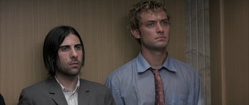 Movie still from “I Heart Huckabees” (2004), directed by David O. Russell – Two men standing next to each other in front of a wall; Close Up shot, Low angle