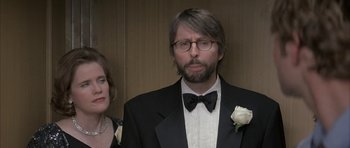 Movie still from “I Heart Huckabees” (2004), directed by David O. Russell – A man in a suit and bow tie standing next to a woman in a dress; Close Up shot, Over the shoulder angle