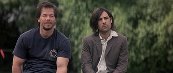 Movie still from “I Heart Huckabees” (2004), directed by David O. Russell – Two men sitting next to each other in a park; Medium shot, Over the shoulder angle