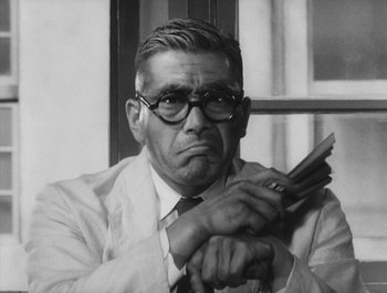 Movie still from “I Live in Fear” (1955), directed by Akira Kurosawa – An older man in a suit and tie holding a cell phone; Close Up shot, Low angle