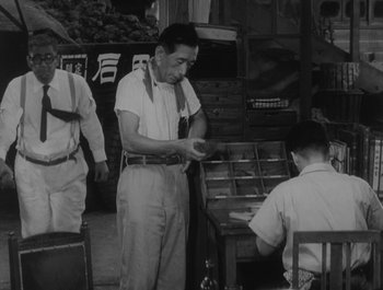 Movie still from “I Live in Fear” (1955), directed by Akira Kurosawa – A group of men standing next to each other in a room; Medium shot, Low angle