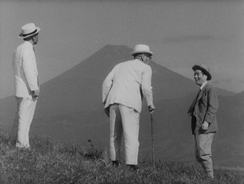 Movie still from “I Live in Fear” (1955), directed by Akira Kurosawa – Three men are standing on a hill with a mountain in the background; Wide shot, Low angle