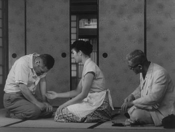 Movie still from “I Live in Fear” (1955), directed by Akira Kurosawa – A group of people sitting on the ground; Medium shot, Low angle