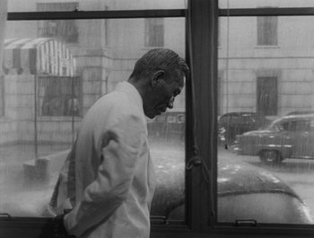 Movie still from “I Live in Fear” (1955), directed by Akira Kurosawa – Black and white photograph of a man looking out of a window; Medium shot, Low angle