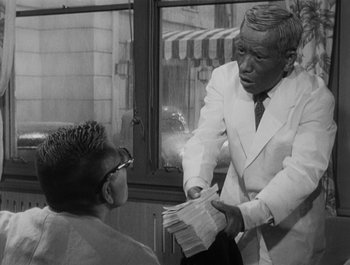 Movie still from “I Live in Fear” (1955), directed by Akira Kurosawa – An older man in a white suit is handing a paper to a young man; Medium shot, Over the shoulder angle