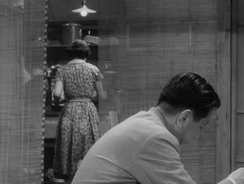 Movie still from “I Live in Fear” (1955), directed by Akira Kurosawa – A man and a woman are looking in the mirror; Medium shot, Over the shoulder angle