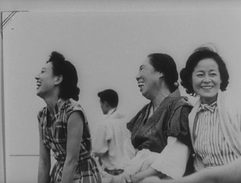 Movie still from “I Live in Fear” (1955), directed by Akira Kurosawa – A black and white photo of a group of women laughing; Medium shot, High angle