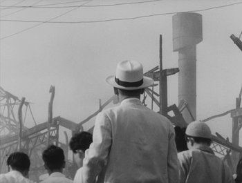 Movie still from “I Live in Fear” (1955), directed by Akira Kurosawa – An old photo of a man wearing a white hat; Medium shot, Low angle