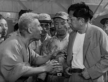 Movie still from “I Live in Fear” (1955), directed by Akira Kurosawa – A group of men standing next to each other; Medium shot, Over the shoulder angle