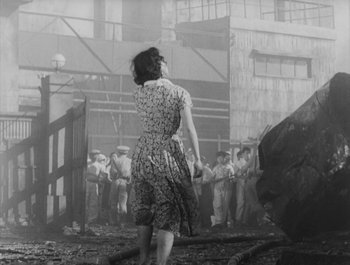 Movie still from “I Live in Fear” (1955), directed by Akira Kurosawa – An old photo of a woman standing in front of a crowd; Wide shot, Low angle