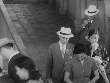 Movie still from “I Live in Fear” (1955), directed by Akira Kurosawa – A group of people walking down a sidewalk; Medium shot, High angle
