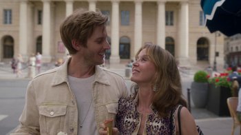 Movie still from “Emily in Paris” (2020), created by Darren Star – A man and a woman standing next to each other in front of a building; Close Up shot, Over the shoulder angle