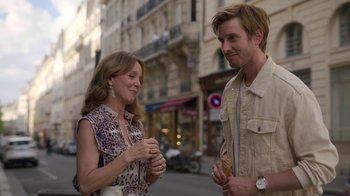 Movie still from “Emily in Paris” (2020), created by Darren Star – A man and a woman standing next to each other on the street; Medium shot, Over the shoulder angle