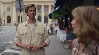 Movie still from “Emily in Paris” (2020), created by Darren Star – A man and a woman standing on a sidewalk; Medium shot, Over the shoulder angle