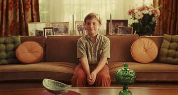 Movie still from “I Love You Phillip Morris” (2009), directed by John Requa – A young boy sitting on a couch in a living room; Medium shot, High angle