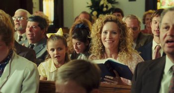 Movie still from “I Love You Phillip Morris” (2009), directed by John Requa – A woman and a child are sitting in a church; Close Up shot, Over the shoulder angle