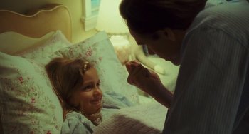 Movie still from “I Love You Phillip Morris” (2009), directed by John Requa – A little girl laying in a bed with a woman; Medium shot, Over the shoulder angle