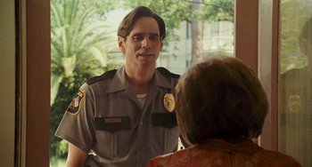 Movie still from “I Love You Phillip Morris” (2009), directed by John Requa – A man in a police uniform talking to a woman; Medium shot, Over the shoulder angle