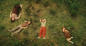 Movie still from “I Love You Phillip Morris” (2009), directed by John Requa – Three children are laying in the middle of a grassy field; Wide shot, Overhead angle