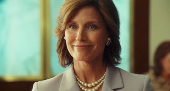 Movie still from “I Love You Phillip Morris” (2009), directed by John Requa – A person wearing a suit and pearl necklace; Close Up shot, Low angle