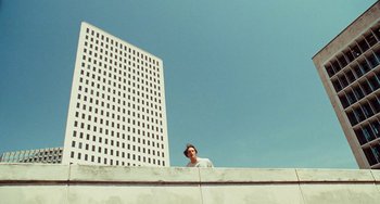 Movie still from “I Love You Phillip Morris” (2009), directed by John Requa – A man standing on top of a building looking at the sky; Extreme Wide shot, Low angle