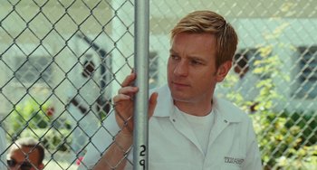 Movie still from “I Love You Phillip Morris” (2009), directed by John Requa – A man standing next to a chain link fence; Close Up shot, Low angle