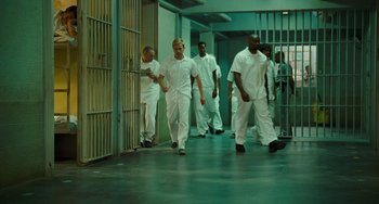 Movie still from “I Love You Phillip Morris” (2009), directed by John Requa – A group of men walking in a hallway next to each other; Wide shot, Low angle