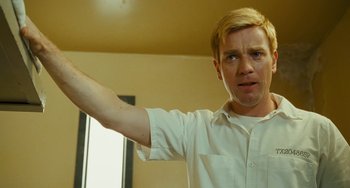 Movie still from “I Love You Phillip Morris” (2009), directed by John Requa – A man in a white shirt is holding his arm up; Close Up shot, Low angle