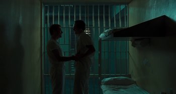 Movie still from “I Love You Phillip Morris” (2009), directed by John Requa – A couple of men standing next to each other in a room; Wide shot, Low angle