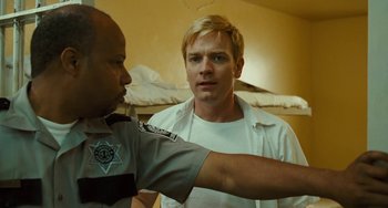 Movie still from “I Love You Phillip Morris” (2009), directed by John Requa – A man in a white shirt is talking to a cop; Close Up shot, Over the shoulder angle