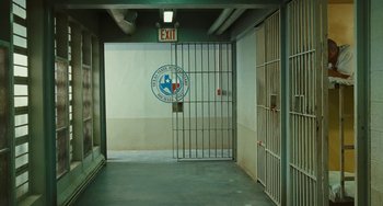 Movie still from “I Love You Phillip Morris” (2009), directed by John Requa – An exit sign in front of a jail cell; Wide shot, High angle