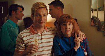 Movie still from “I Love You Phillip Morris” (2009), directed by John Requa – A man and a woman standing next to each other holding a glass; Medium shot, Over the shoulder angle