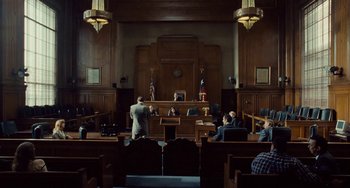 Movie still from “I Love You Phillip Morris” (2009), directed by John Requa – A court room filled with people sitting in chairs; Extreme Wide shot, Low angle