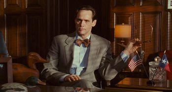 Movie still from “I Love You Phillip Morris” (2009), directed by John Requa – A man sitting at a table wearing a bow tie; Medium shot, Low angle