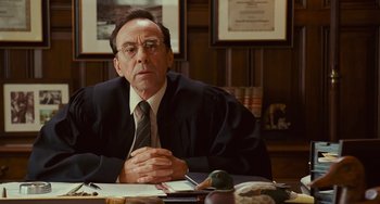 Movie still from “I Love You Phillip Morris” (2009), directed by John Requa – An older man sitting at a table in front of some food; Close Up shot, Over the shoulder angle