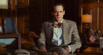 Movie still from “I Love You Phillip Morris” (2009), directed by John Requa – A man in a suit and bow tie sitting in a chair; Medium shot, Over the shoulder angle