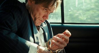 Movie still from “I Love You Phillip Morris” (2009), directed by John Requa – A man holding a pair of glasses while sitting in a car; Close Up shot, Low angle