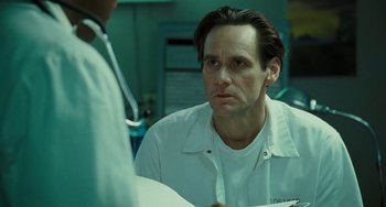Movie still from “I Love You Phillip Morris” (2009), directed by John Requa – A man wearing a white shirt is talking to a doctor; Close Up shot, Over the shoulder angle