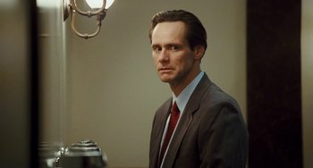 Movie still from “I Love You Phillip Morris” (2009), directed by John Requa – A man wearing a suit and tie in front of a lamp; Close Up shot, Low angle