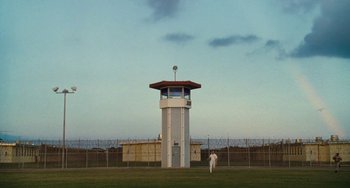 Movie still from “I Love You Phillip Morris” (2009), directed by John Requa – A man standing next to a tall tower in the middle of a field; Extreme Wide shot, Low angle