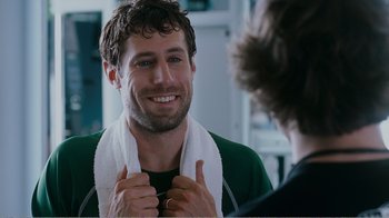 Movie still from “I Love You, Man” (2009), directed by John Hamburg – A man with a towel around his neck smiles at a mirror; Close Up shot, Over the shoulder angle
