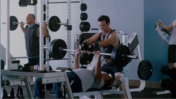 Movie still from “I Love You, Man” (2009), directed by John Hamburg – A man is lifting a barbell in a gym; Medium shot, Over the shoulder angle